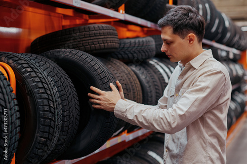 male customer choosing new tires in the supermarket .