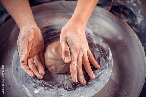 Potter female student working with pottery at the ceramic workshop. Concept for woman in freelance, business, hobby. Close-up. photo