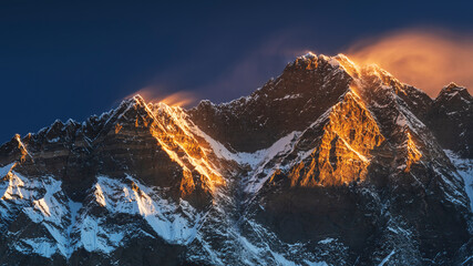 first sun lights on the peaks of Lhotse and Nutse under blue sky in Nepal