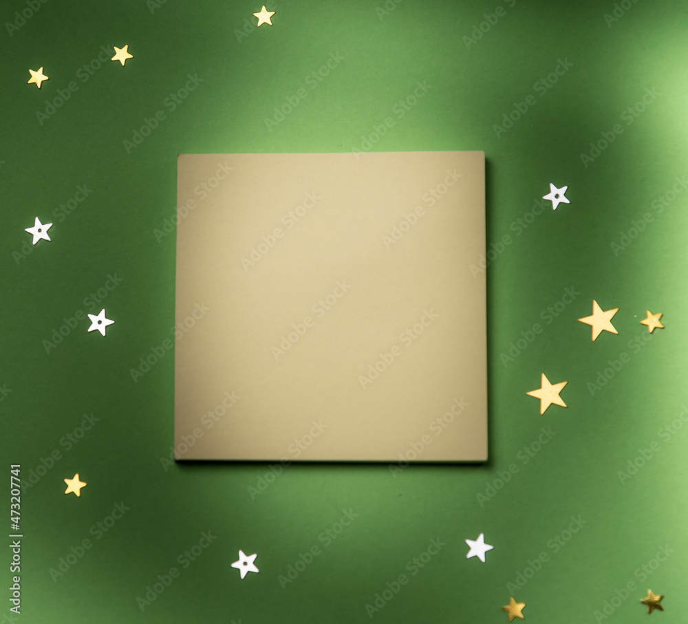 Yellow memo stick on green background with stars