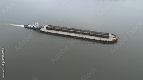 The barge floats on the river. Shooting from the air.