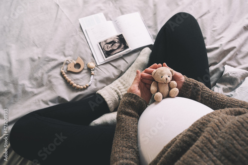 Quadro su tela Woman pregnant belly with little teddy toy bear