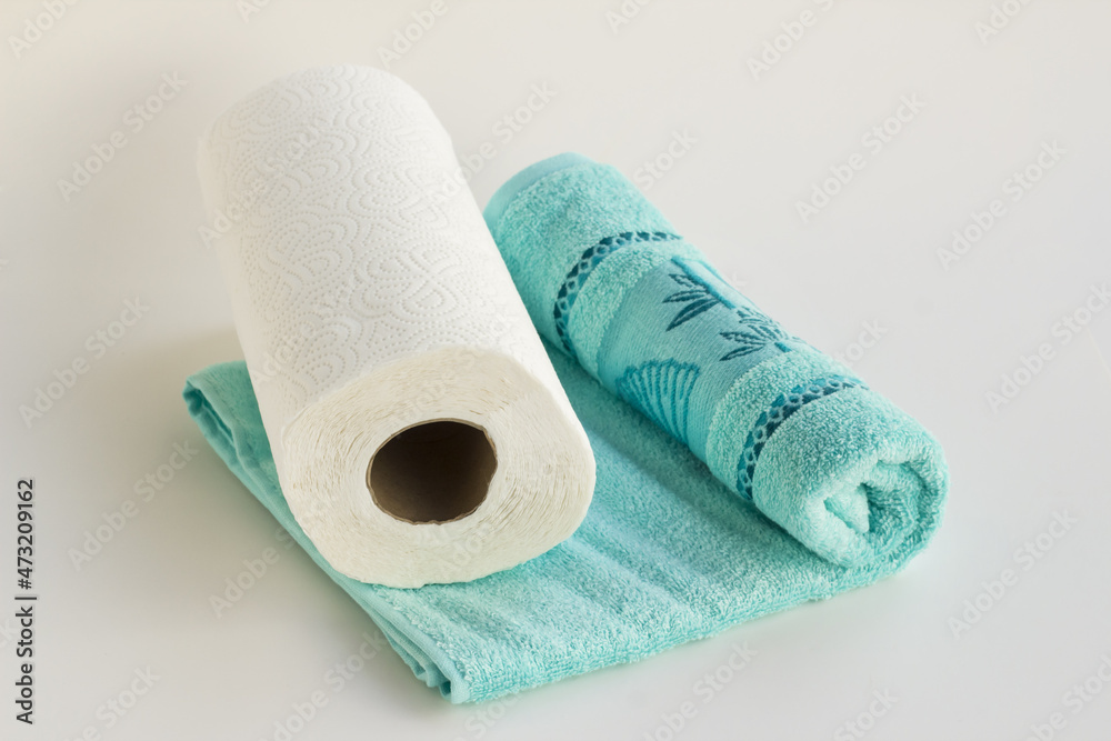 Obraz premium Clean face towel in blue color with paper towel on white background