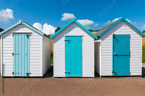 Colorful small beach houses. Multicolored beach sheds. Variety of painted beach shacks. Beach hut. 
