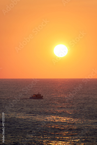 barco de pesca volviendo a puerto bajo el sol del atardecer