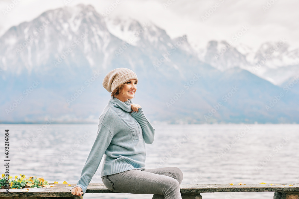 Outdoor portrait of beautiful young woman relaxing by mountain lake, cold weather Outdoor portrait of beautiful young woman relaxing by mountain lake, cold weather