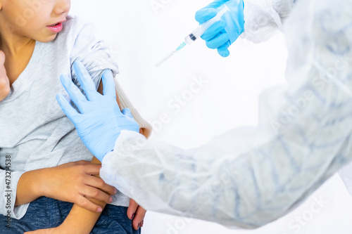 A female doctor calming the child with his mother before the vaccine injection. Vaccination of children. Immunization in the coronavirus pandemic  covid-19