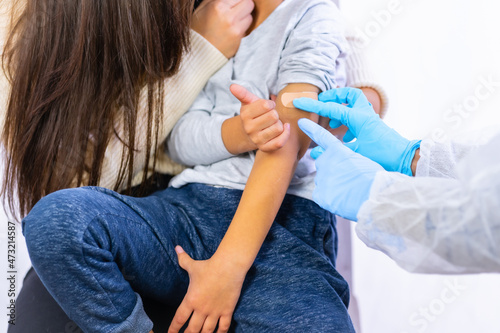 Scared child after vaccination injection by a female doctor. Vaccination of children. Immunization in the coronavirus pandemic  covid-19