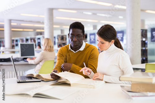 Couple of adult students studying together in public library. High quality photo