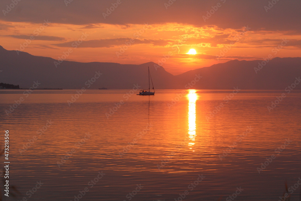 Scenic sunset and a lonely sailboat at the coast of Trogir Scenic sunset and a lonely sailboat at the coast of Trogir