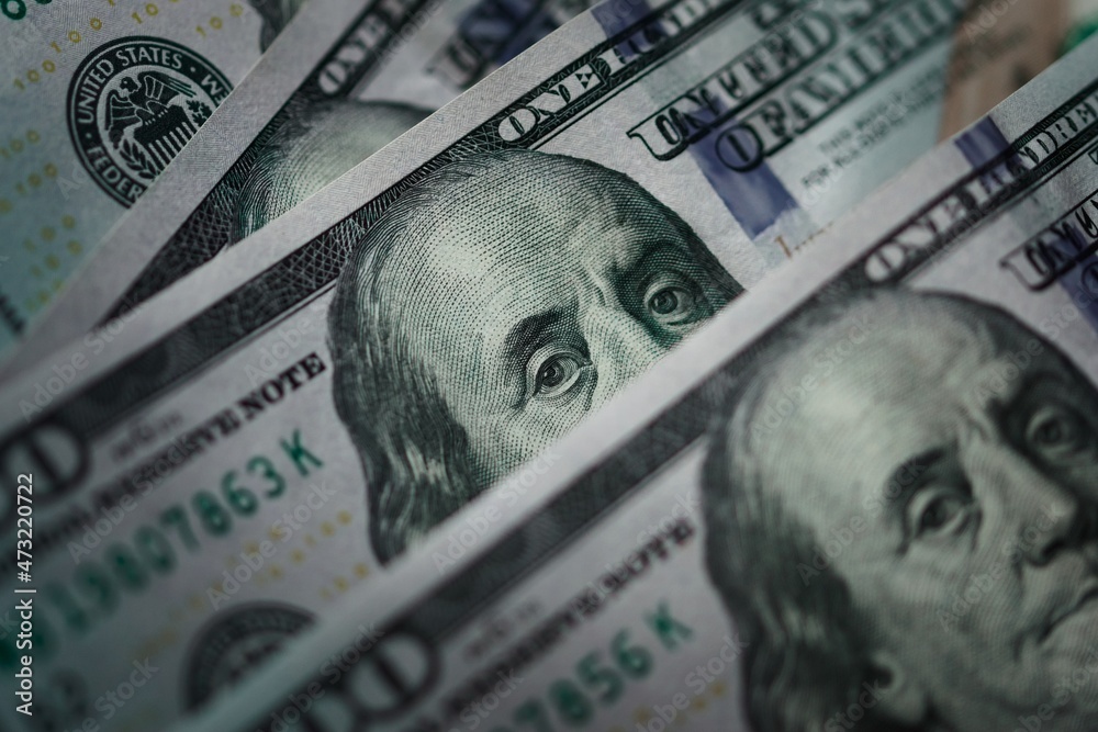 Several one hundred dolar bills. Extreme macro close up, focusing on the eyes of Benjamin Franklin. - obrazy, fototapety, plakaty 