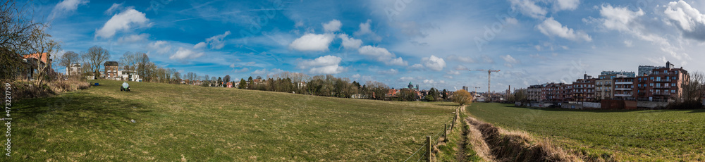 Berchem Sainte Agathe, Brussels Capital Region, Belgium 03 05 2018: Panoramic view over the green fields and meadows of Hoogveld with residentail houses in the background