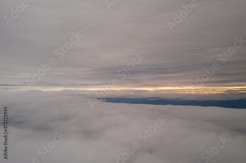 In Between the Clouds With a Sunrise in the Distance