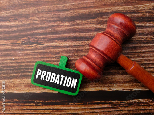 Gavel and wooden board with word PROBATION on a wooden background.