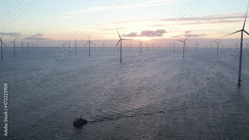 Ship floating in Ijsselmeer lake at Windpark Friesland during sunrise, aerial photo
