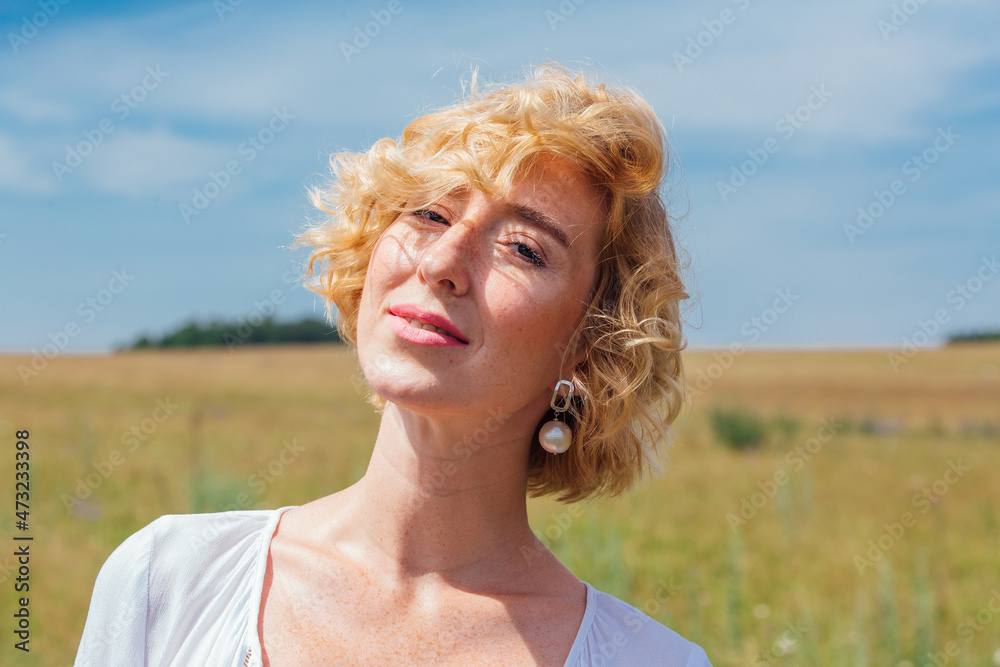 Beautiful blonde woman with short curly hair outdoors. Beautiful blonde woman with short curly hair outdoors.