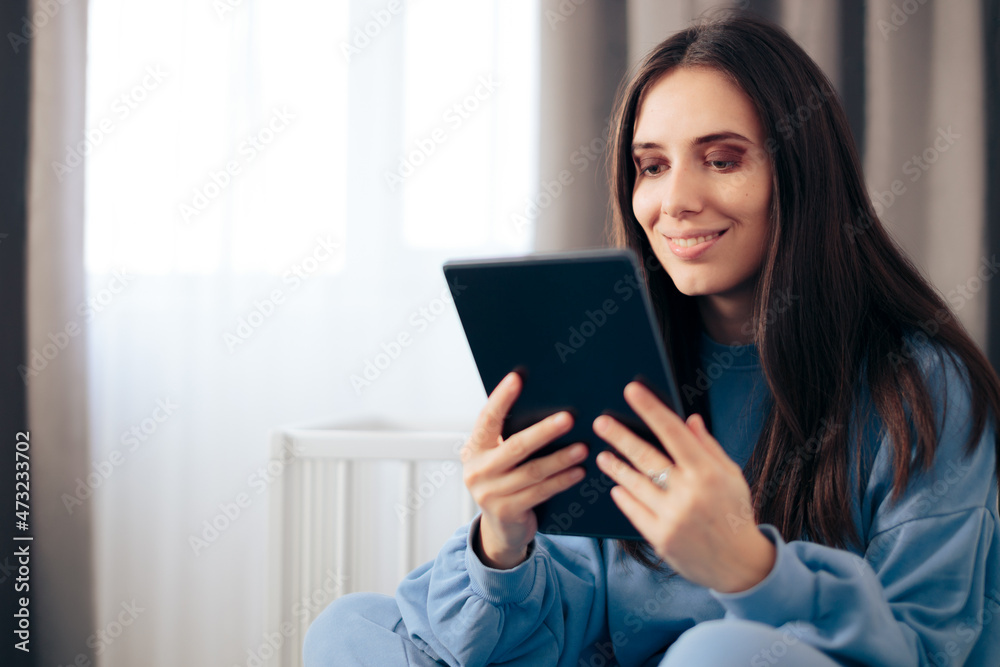 Happy Woman Checking PC Tablet Sitting in Bed Happy Woman Checking PC Tablet Sitting in Bed
