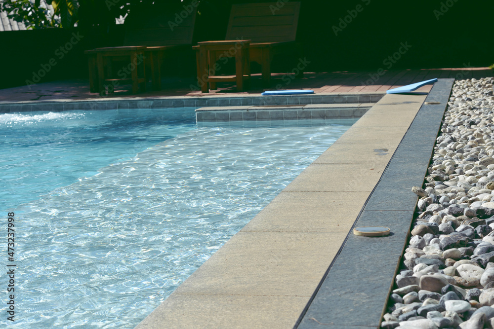Blue swimming pool with rock flooring stripes summer vacation.