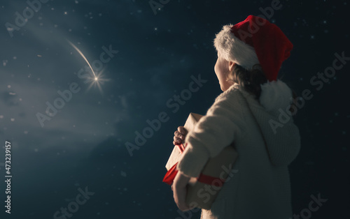 kid is making wish looking at falling star photo