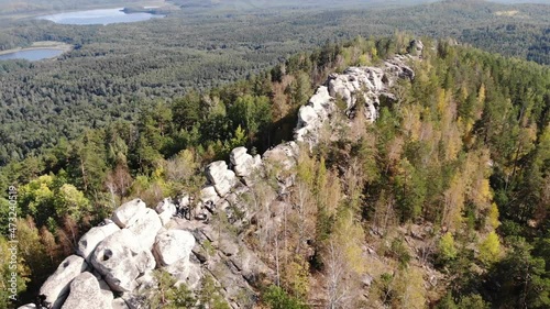 Aerial view of the rocky massif, Arakul Shikhany, Ural. The mountain elevation is located among dense green forest near lakes. Clear weather. Hiking, tourism, wild nature photo