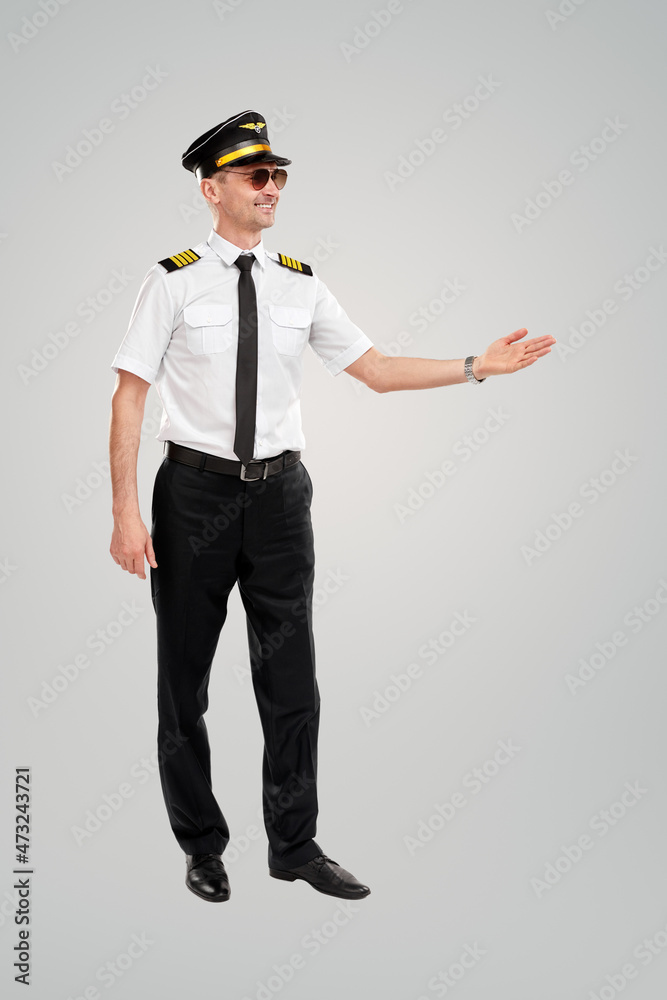 Cheerful pilot pointing aside in studio Cheerful pilot pointing aside in studio