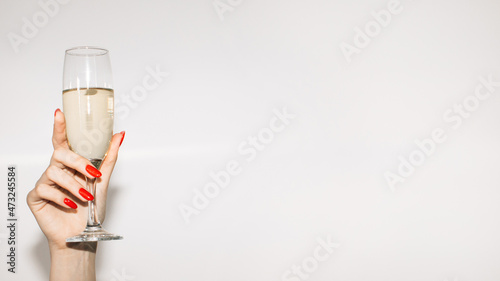 Party cheer. Happy womans day. Festive celebration. Advertising background. Elegant female hand red nail polish holding glass of champagne isolated white copy space.