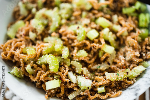 vegan instant noodles with ginger and soy sauce topped with celeri corainder seeds and chilli flakes, healthy plant-based food photo