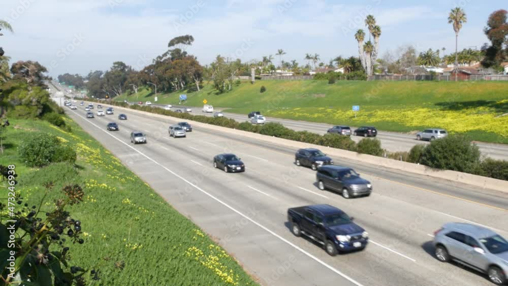 Cars on interstate highway 5, Oceanside California USA. Automobiles on intercity freeway. Auto transport in America. Road traffic and greenery near Los Angeles. Multiple lane thoroughfare from above.