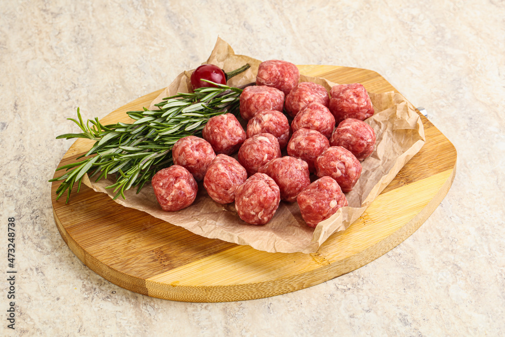 Raw uncooked beef meatballs served rosemary Raw uncooked beef meatballs served rosemary