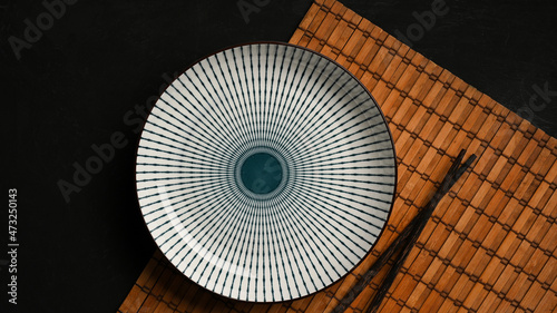 Fotografie Table setting with blue and white ceramic plate with chopstick on bamboo placema