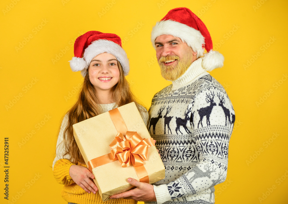 They love Christmas. family exchange presents. winter xmas mood. new year is here. dad and small girl santa hat. funny knitted sweater. father and daughter celebrate christmas. xmas party together They love Christmas. family exchange presents. winter xmas mood. new year is here. dad and small girl santa hat. funny knitted sweater. father and daughter celebrate christmas. xmas party together