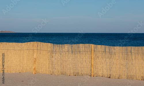 a dry reed fence on the beach
