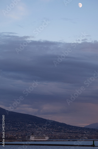 View outdoor deck luxury cruiseship cruise ship liner with railing superstructure onto Vesuv volcano and skyline MSC vessel in Naples Napoli Italy sunset twilight blue hour dusk evening container port photo