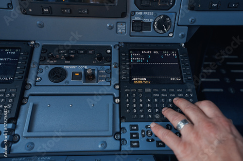 Pilot inserting flight information into plane system