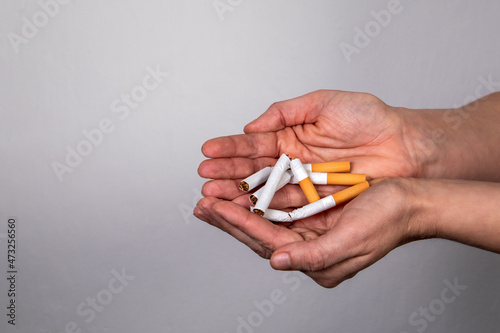 Stack of broken cigarettes in a woman's hands. Quit smoking