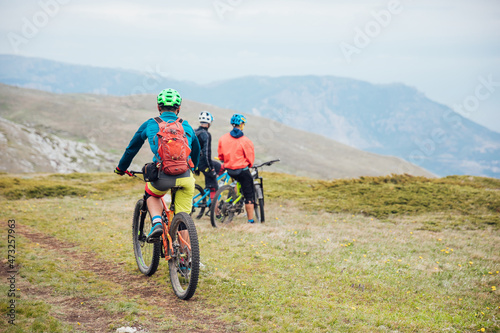 mountain bikers on top of the mountain look at the view on a journey