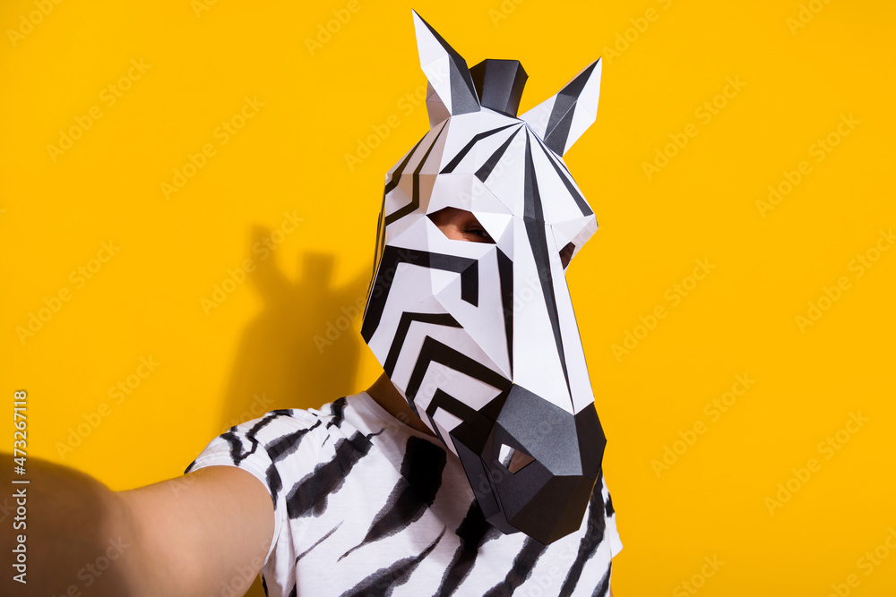 Portrait of bizarre surreal guy in zebra mask make selfie video call theme festival isolated over yellow color background Portrait of bizarre surreal guy in zebra mask make selfie video call theme festival isolated over yellow color background