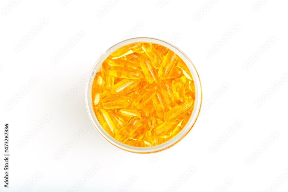 Fish oil in gelatin capsules isolate. Omega vitamins in golden colored pills on a blank white background. Medicine, pharmacy, drugs and multivitamins oils concept