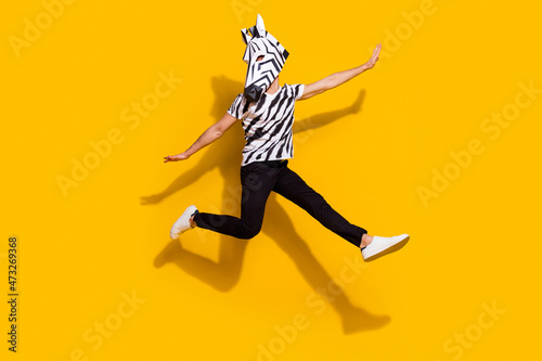 Full size photo of bizarre unusual guy zebra character jump up enjoy theme festival isolated over shine yellow color background