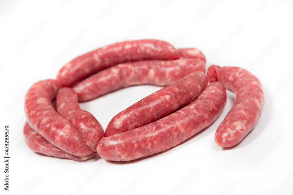 Many crude sausages on a white background
