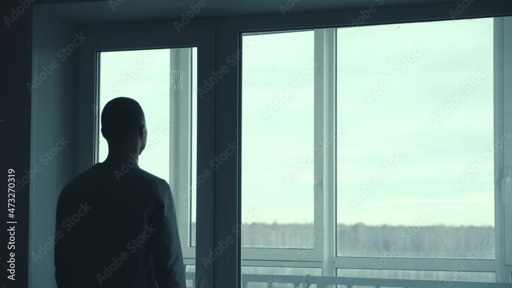A Man Looks Out Of The Window Of His Apartment. Man Looking Out The Window And Making Plans For The Future A Man Looks Out Of The Window Of His Apartment. Man Looking Out The Window And Making Plans For The Future
