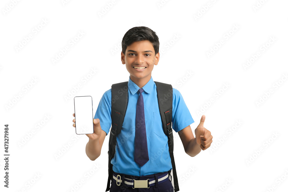technology concept: Cute indian little school boy showing smartphone technology concept: Cute indian little school boy showing smartphone