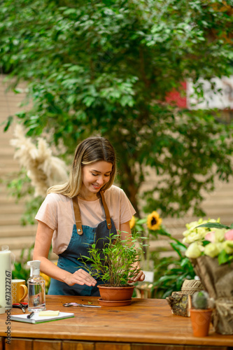Woman florist taking care of a plant in a flower shop