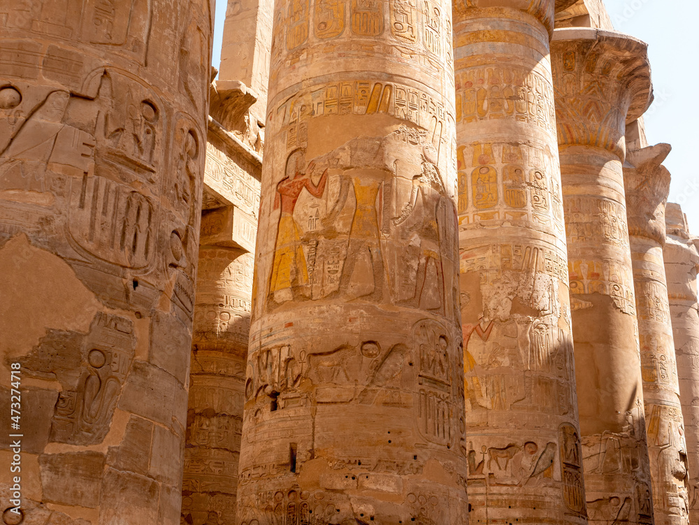 Stone columns with Egyptian hieroglyphs and ancient drawings in the Karnak temple. Close-up. Luxor, Egypt. Stone columns with Egyptian hieroglyphs and ancient drawings in the Karnak temple. Close-up. Luxor, Egypt.