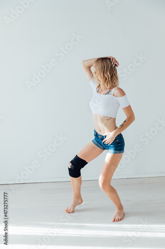 athletic woman blonde dancing to music alone