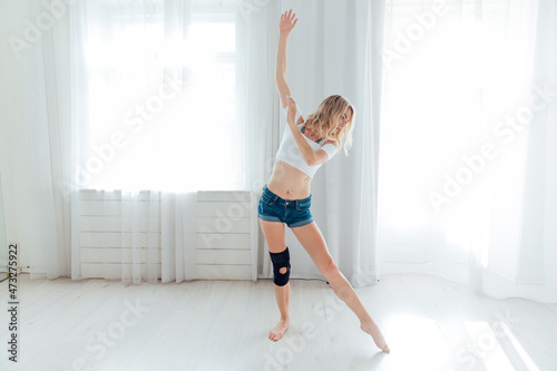 athletic woman blonde dancing to music alone