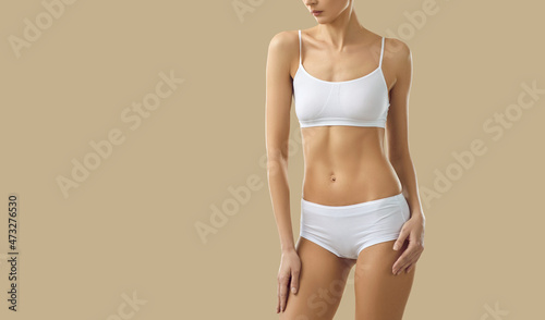 Photos Close up of toned slim female model in underwear isolated on yellow studio background