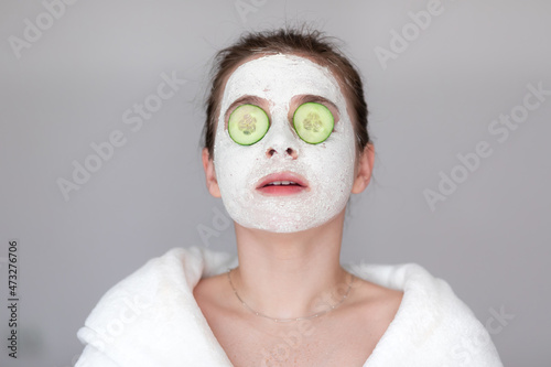 Fototapeta Naklejka Na Ścianę i Meble -  Attractive young woman with a facial mask on her skin