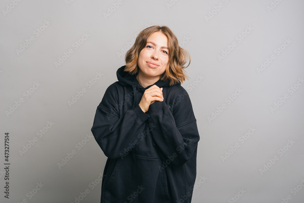 A beautiful portrait of a nice young woman looking at the camera wearing a hoodie and smiling lightly . A beautiful portrait of a nice young woman looking at the camera wearing a hoodie and smiling lightly .