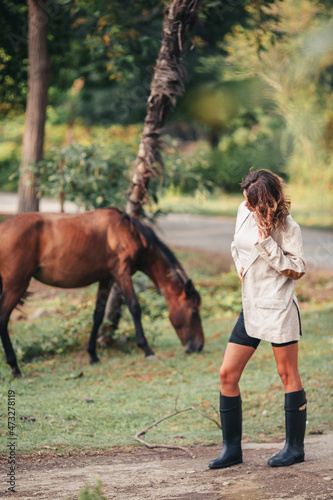 Young woman with wild horse outdoors